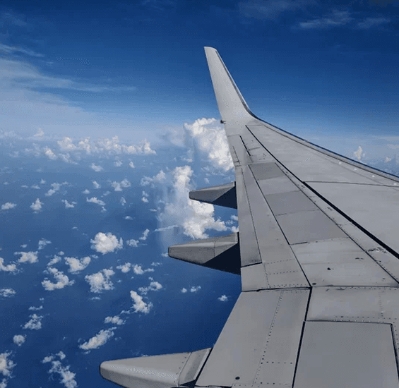 Scenic Aircraft Wing View Over Oceanic Clouds